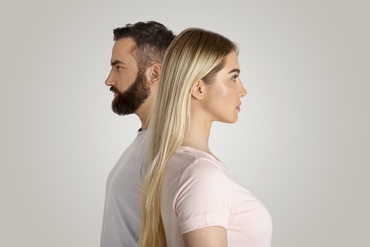 Divergent views, sexism and feminism, inequality, financial, social superiority, gender gap concept. Serious young guy and lady stand side by side and look in different directions, on gray background
