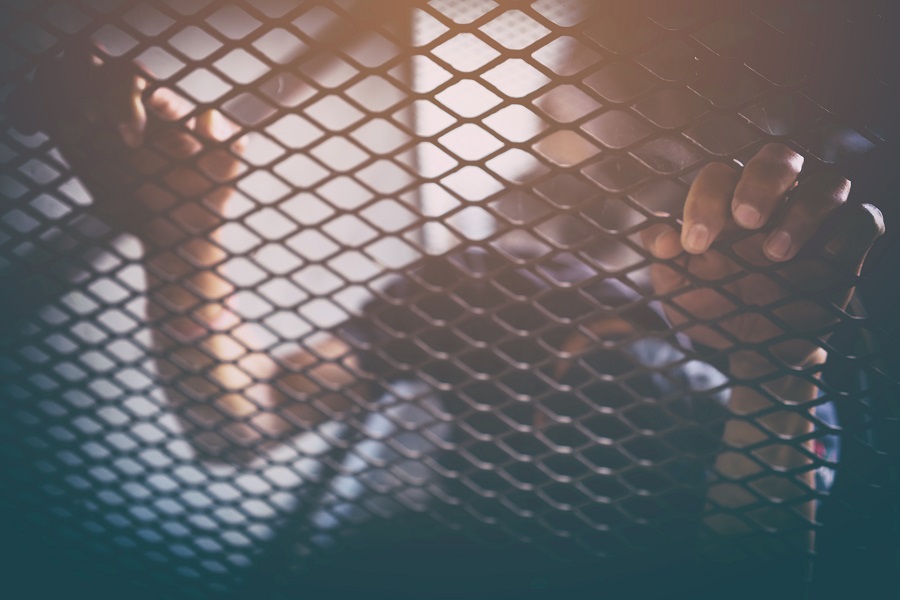 human trafficking, man in cage with orange light